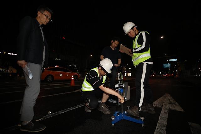 28일 오전 서울 양재역 인근 도로에서 미세먼지의 원인이 되는 질소산화물 정화기능이 있는 ‘광촉매’를 시험 포장하는 작업이 진행되고 있다. [연합뉴스]