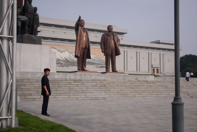 A North Korean citizen stands in front of statues of late North Korean leaders Kim Il-sung and Kim Jong-il on Mansu Hill in Pyongyang. (Yonhap)
