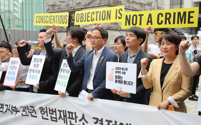 Peace activists attend a rally in front of the Constitutional Court in central Seoul on Thursday. The court ruled that not providing alternative measures for conscientious objectors is against the Constitution on the same day.(Yonhap)