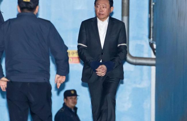 Shin Dong-bin, chairman of Lotte Group, right, walks towards a prison bus at the Seoul Central District Court after he was convicted of bribery. (Bloomberg)