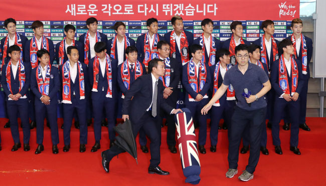 Security officials clear away a pillow thrown toward the South Korean men's national football team at Incheon International Airport after the players' return from the FIFA World Cup in Russia on June 29. (Yonhap)