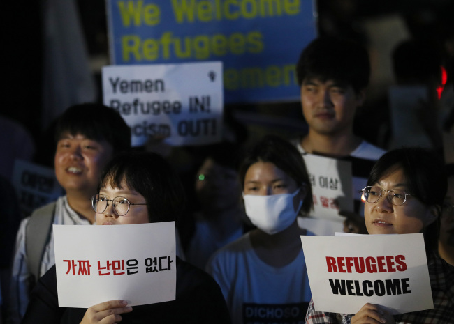 Signs read, 'There are no fake refugees,' 'Refugees welcome' (Yonhap)