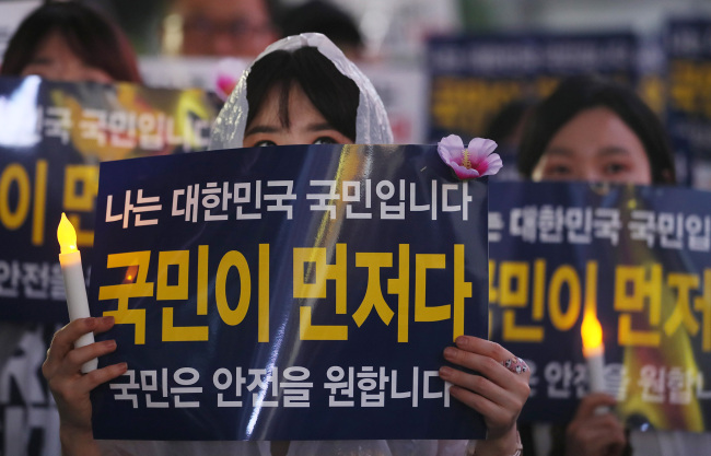 Signs read, 'Koreans first,' 'Korean people want safety' (Yonhap)