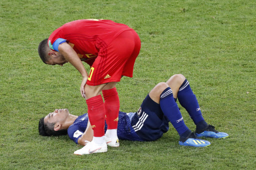 Belgium's forward Eden Hazard consoles Japan's midfielder Shinji Kagawa (back) as he lies on the ground at the end of the Russia 2018 World Cup round of 16 football match between Belgium and Japan at the Rostov Arena in Rostov-On-Don on July 2, 2018. / AFP PHOTO