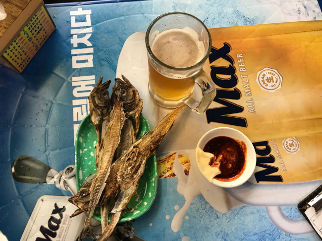 A cold glass of beer is served with nogari and special sauce. A nogari fillet is sold for 1,000 won ($0.90), and a glass of beer goes for 3,500. (Yeo Jun-suk/The Korea Herald)