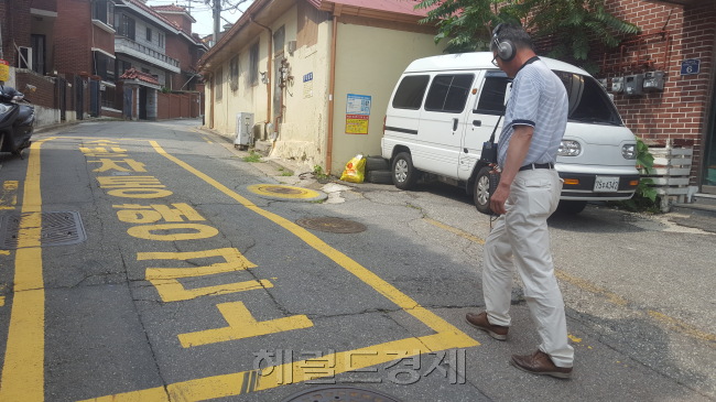 지난 4일 서울 용산구 주성동의 한 주택가에서 박문종 누수탐지전문관이 누수 감지기를 통해 땅 속 물이 새는 상수도관을 찾고 있는 모습(왼쪽)과 서울시 상수도사업본부 관계자가 맨홀 안을 살펴보고 있는 모습(가운데), 맨홀 안으로 누수 탐지기를 넣고 있는 모습(오른쪽). 이원율 기자/yul@