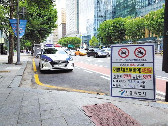 서울 도심 한복판인 종로 1∼6가 2.6km 구간에 자전거 전용도로가 개통한지 3개월, 계도기간을 거쳐 지난 1일부터 자전거전용차로 위반을 강력히 단속했지만 위반하는 차량이나 오토바이가 적잖다. 자전거전용차로를 위반하면 자가용 5만원ㆍ오토바이 4만원ㆍ승합차 6만원의 과태료를 내야 한다. 사진은 5일 오전 종로 자전거전용도로의 모습. 정희조 기자/checho@