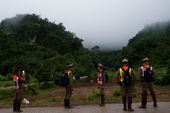 Thai police guard a road leading to the Tham Luang cave area as operations continue for the remaining eight boys and their coach trapped at the cave in Khun Nam Nang Non Forest Park in the Mae Sai district of Chiang Rai province on July 9, 2018. (AFP-Yonhap)