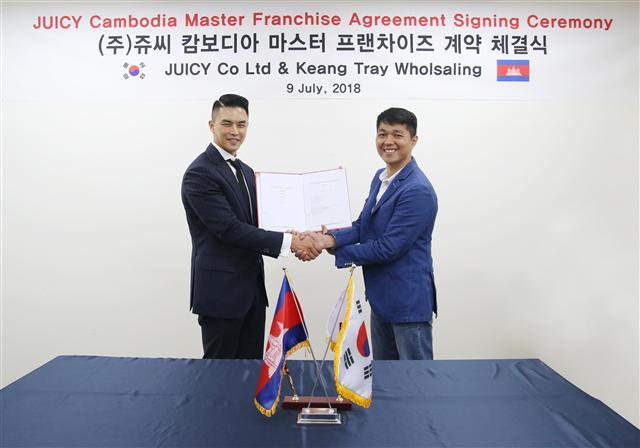 윤석제(왼쪽) 쥬씨 대표이사와 뜨라이 뿌틴 나인닷츠사 이사가 캄보디아 마스터프랜차이즈(MF) 계약 체결식을 갖고 있다.
