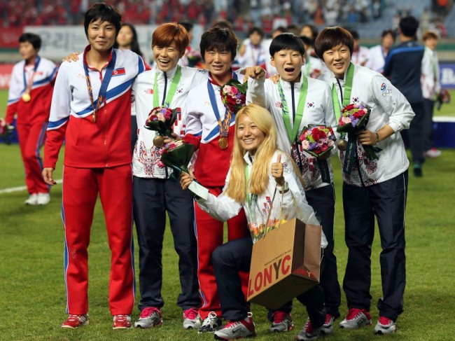 The players from the two Koreas mingled for souvenir photos after the medal ceremony, celebrating the North's victory over Japan in women's football during the 2014 Asian Games. (Yonhap)
