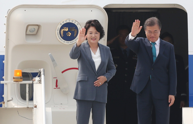President Moon Jae-in and First Lady Kim Jung-sook wave before departing New Delhi for Singapore on Wednesday. Yonhap