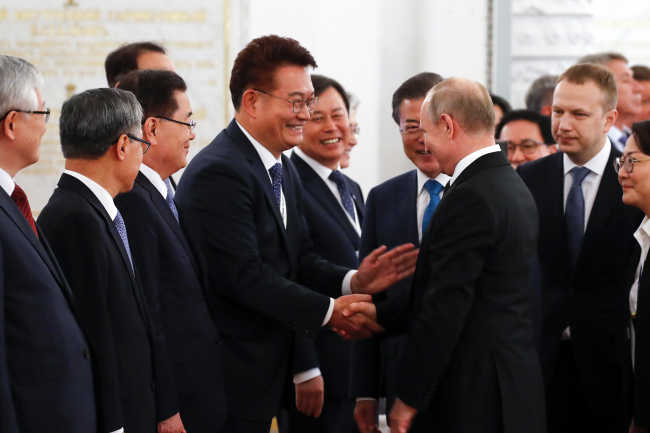 Song Young-gil, Chairman of the Presidential Committee on Northern Economic Cooperation (left) shakes hands with Russian President Vladimir Putin (right) in Moscow on June 22. (Yonhap)