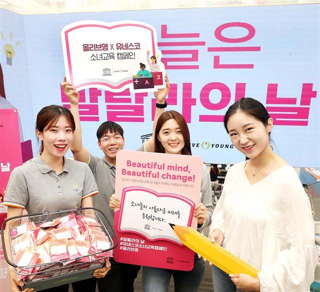 올리브영 명동본점을 찾은 고객들이 12일 유엔(UN)이 제정한 ‘말랄라의 날’을 맞아 직원들과 함께 유네스코 소녀교육 캠페인에 참여하고 있다. 올리브영은 이날 기부 연계 제품을 구매한 고객들에게 소녀교육을 상징하는 책 모양의 ‘포스트 잇’을 선물했다.