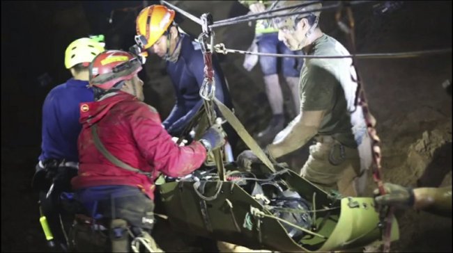 This updated photo from video released via the Thai NavySEAL Facebook Page on Wednesday, July 11, shows rescuers hold an evacuated boy inside the Tham Luang Nang Non cave in Mae Sai, Chiang Rai province, in northern Thailand. (AP)
