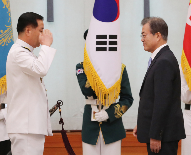 Adm. Sim Seung-seob salutes President Moon Jae-in after being sworn in as the Navy's new chief of naval operations on Thursday. Yonhap