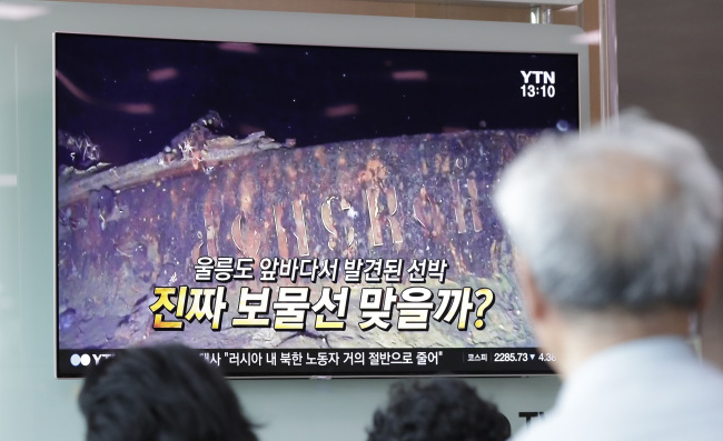 People watch a TV screen showing the news program reporting about a sunken Russian warship at the Seoul Railway Station in Seoul, South Korea, Thursday, July 19, 2018. A South Korean company's claim to have found a sunken Russian warship has triggered investor frenzy amid unconfirmed rumors that the ship was carrying 200 tons of gold when it sank in 1905. The letters read "Is it real treasure ship?" (Yonhap)
