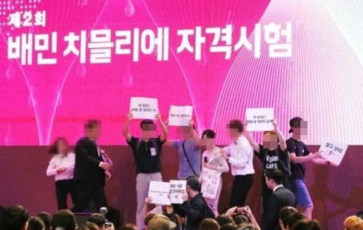 22일 오후 서울 송파구 잠실 롯데호텔에서 배달의민족 주최로 열린 제2회 배민 치믈리에 자격시험 오프닝 행사에 동물보호 활동가들이 손팻말을 들고 기습시위를 하고 있다. '치믈리에'란 치킨 감별사를 뜻하는 말로 치킨 영역의 소믈리에다. (연합뉴스)