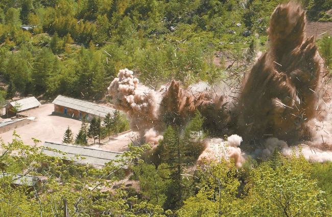 Smoke and debris rise as barracks for workers at North Korea's nuclear test site at Punggye-ri are blown up on May 24. (AP-Yonhap)