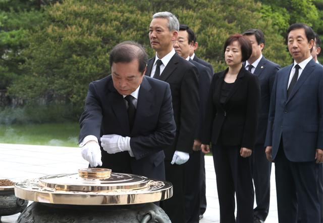 자유한국당 김병준 혁신비상대책위원장이 비대위 체제 공식 출범 첫날인 25일 오전 서울 동작구 국립서울현충원에서 분향하고 있다. 김 위원장은 현충원에서 비대위원 8명과 김성태 원내대표, 김용태 사무총장, 홍철호 비서실장, 윤영석 배현진 대변인 등과 함께 호국영령의 넋을 기리고, 전직 대통령들의 묘역도 참배했다.  [연합뉴스]