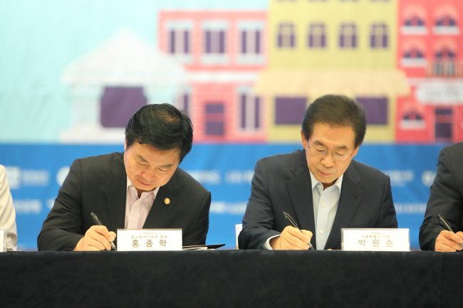 홍종학 중소벤처기업부 장관은 소상공인 수수료 부담제로 결제서비스 도입을 위한 업무협약식에서 서명을 하고 있다. 사진 왼쪽 두번째 홍종학 중소벤처기업부 장관, 박원순 서울시장.
