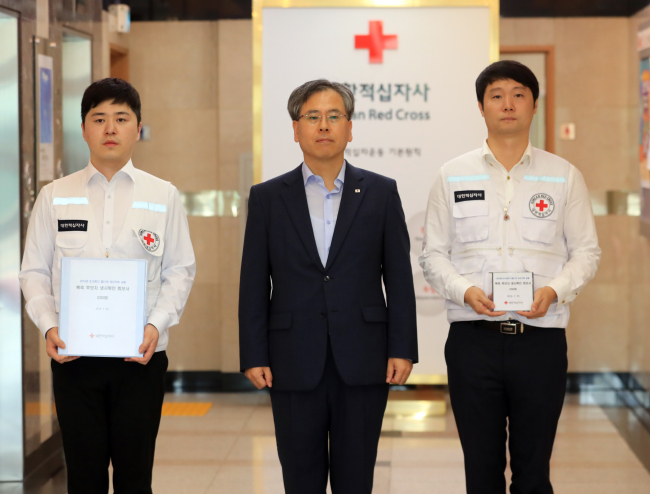 Korean Red Cross employees holding documents of results of their search for families separated by the 1950-53 Korean War on Wednesday. (Yonhap)