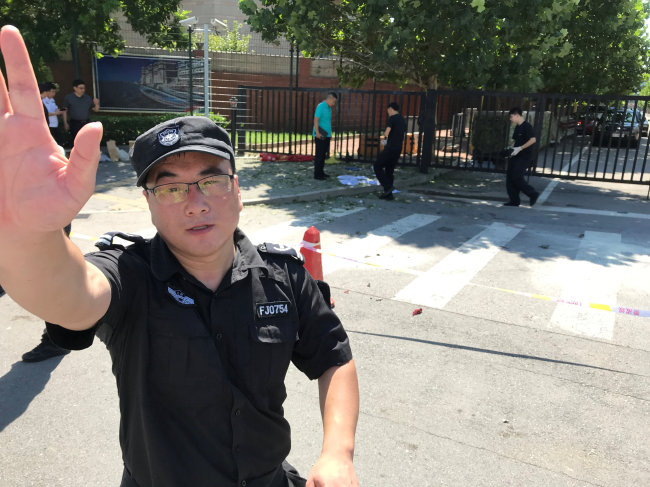 <YONHAP PHOTO-4773> A security personnel gestures near the U.S. embassy in Beijing, China July 26, 2018. REUTERS/ Thomas Peter/2018-07-26 15:28:38/ <저작권자 ⓒ 1980-2018 ㈜연합뉴스. 무단 전재 재배포 금지.>
<YONHAP PHOTO-4773> A security personnel gestures near the U.S. embassy in Beijing, China July 26, 2018. REUTERS/ Thomas Peter/2018-07-26 15:28:38/ <저작권자 ⓒ 1980-2018 ㈜연합뉴스. 무단 전재 재배포 금지.>