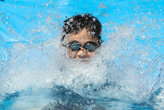 A child goes down a water slide in a pool set up in Jongno-gu, Seoul, Sunday.