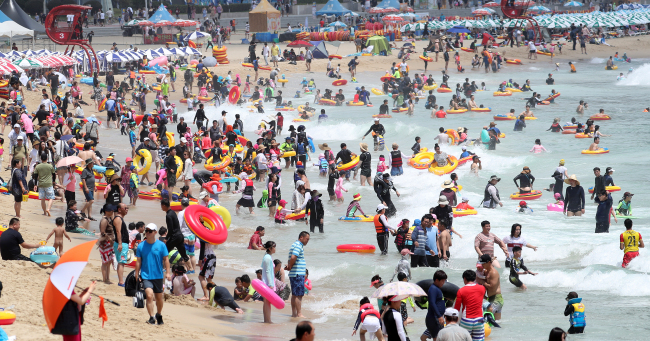 Around 450,000 people flock to beaches at Haeundae, Busan, Saturday.