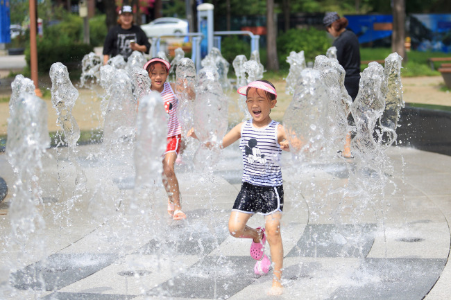 Children play at a fountain in Inje County, Gangwon Province, Monday.