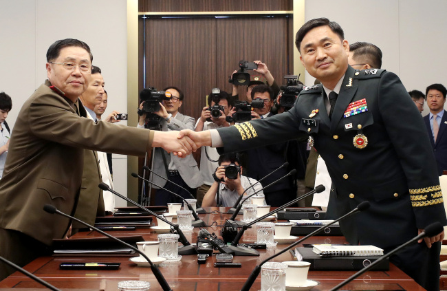 South Korean chief delegate Maj. Gen Kim Do-gyun shakes hands with his North Korean counterpart An Ik-san during a general-level military talks held at Panmunjeom Tuesday. Yonhap