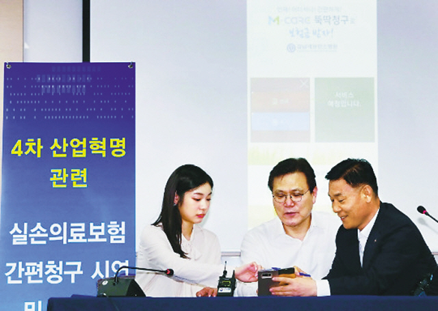 최종구 금융위원장(가운데)이 ‘인슈테크를 활용한 실손의료보험 간편청구 시연 및 간담회’에 참석해 KB손해보험 광고 모델인 김연아씨와 스마트폰으로 보험금 간편청구를 해보고 있다.
[연합뉴스]