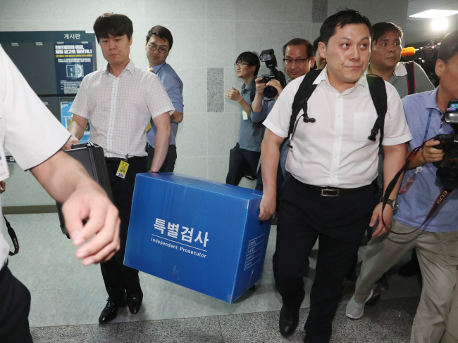 Investigators on Thursday collect materials from the National Assembly office used by South Gyeongsang Provice Gov. Kim Kyoung-soo while he served as a lawmaker. Yonhap