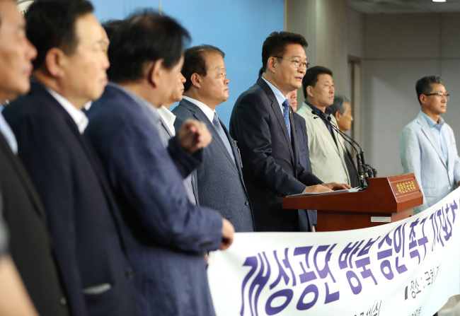 A group of South Korean businessmen who ran factories at Kaesong industrial park and Rep. Song Young-gil (center) of the ruling Democratic Party call for the government to allow the group to revisit the area, during a press conference at the National Assembly in Seoul on July 11. (Yonhap)