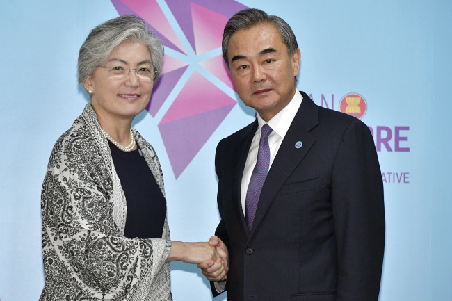 China's Foreign Minister Wang Yi, right, and South Korea's Foreign Minister Kang Kyung-wha pose for a photo ahead of a bilateral meeting on the sidelines of the 51st ASEAN Foreign Ministers Meeting in Singapore, Friday, Aug. 3. (AP-Yonhap)