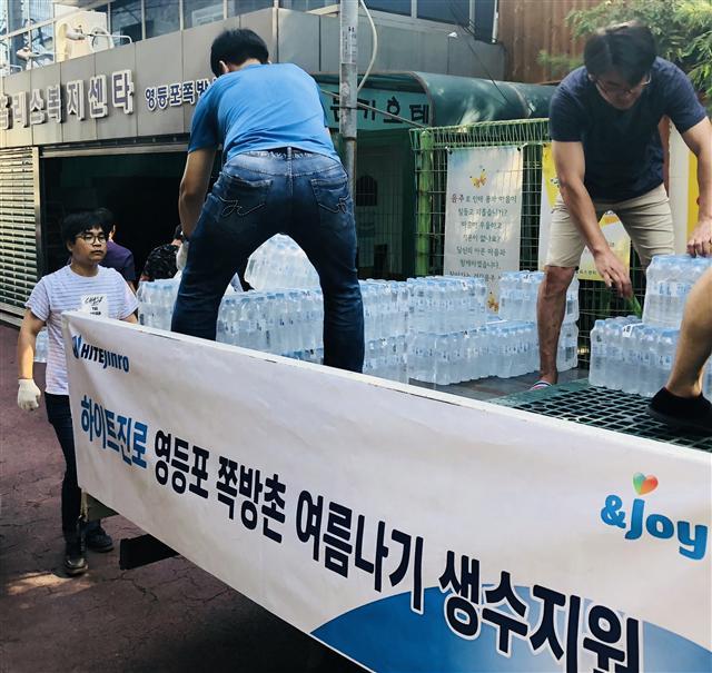 하이트진로 직원들이 지난 2일 서울 영등포 쪽방촌에 생수 6000여병을 긴급 지원하고 있다(위 사진). 엘앤피코스메틱 직원들이 지난 1일 서울 강서구 화곡동 어르신주거보호시설을 찾아 선풍기를 조립해 설치하고 있다.