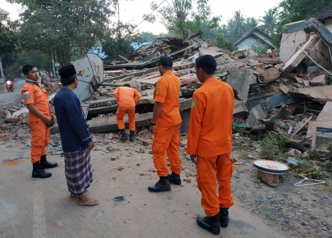 A handout photo made available by Indonesian Search and Rescue (Basarnas) shows rescuers inspecting collapsed houses after an earthquake struck in North Lombok, West Nusa Tenggara, Indonesia, Aug. 6. (EPA-Yonhap)