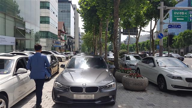 인도에 불법 주차된 BMW 사이를 지나야 하는 시민들은 불편과 함께 화재가 날지도 모른다는 불안감을 호소했다.  유오상 기자/osyoo@