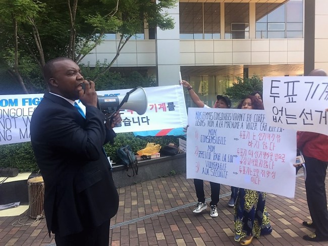 Bwelungu Nombi Henry, a Congolese activist living in South Korea, protests against Miru Systems, a Korean firm that has signed a deal to supply its controversial voting devices to Congo's upcoming election in December, in Pangyo, Gyeonggi Province, on July 16. (Yonhap)
