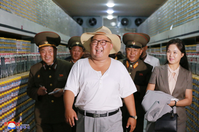 North Korean leader Kim Jong-un and his wife Ri Sol-ju inspect a factory manufacturing jeotgal, or salt-fermented seafood, in Hwanghae Province, North Korea, on Aug. 8.  (Yonhap)