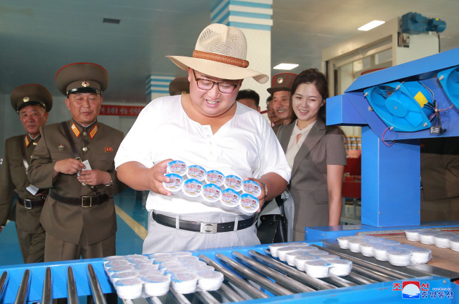 North Korean leader Kim Jong-un and his wife Ri Sol-ju inspect a factory manufacturing jeotgal, or salt-fermented seafood, in Hwanghae Province, North Korea, on Aug. 8. (Yonhap)