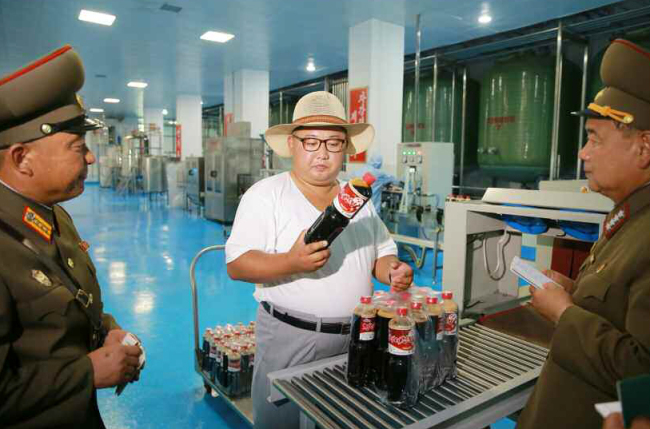 North Korean leader Kim Jong-un and his wife Ri Sol-ju inspect a factory manufacturing jeotgal, or salt-fermented seafood, in Hwanghae Province, North Korea, on Aug. 8. (Yonhap)