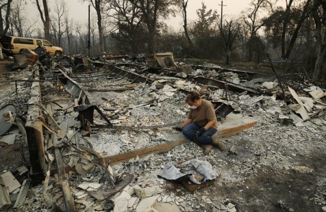 Kim Burns sifts through the charred rubble of her home burned in the Carr Fire, Sunday, Aug. 12, in Redding, California. (AP)