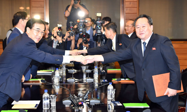 South Korean Unification Minister Cho Myoung-gyon (left) and Ri Son-gwon, chairman of the North's Committee for the Peaceful Reunification of the Country, shake hands at Panmunjom on Monday. Yonhap