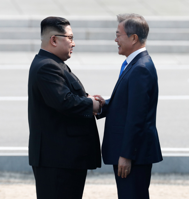 President Moon Jae-in and North Korean leader Kim Jong-un shake hands at Panmunjom at their first summit on April 27. Cheong Wa Dae