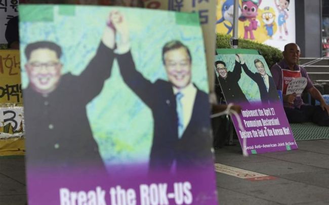 Photos showing North Korean leader Kim Jong-un (left) and South Korean President Moon Jae-in are displayed to demand withdrawal of US troops from Korean Peninsula near the US Embassy in Seoul on Monday. (AP-Yonhap)