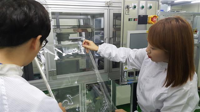 코오롱인더스트리 연구원들이 세계 최초로 개발한 투명폴리이미드 필름인 CPI 필름을 점검하고 있다