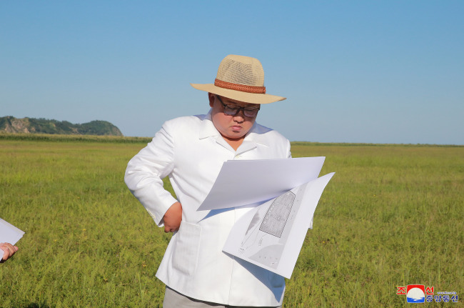 In this file photo dated Aug. 18, North Korean leader Kim Jong-un inspects a plan to build a green house farming facility in North Hamgyong province. (Yonhap)