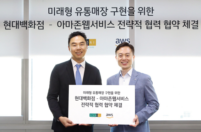 현대백화점그룹이 세계 최대 온라인 유통업체 아마존과 손잡고 ‘미래형 유통매장’을 도입키로 해 업계의 시선을 끌고 있다. 정지영<왼쪽> 현대백화점 영업전략실장과 장정욱 아마존웹서비스코리아 대표가 협약을 체결하고 있다.  [제공=현대백화점]