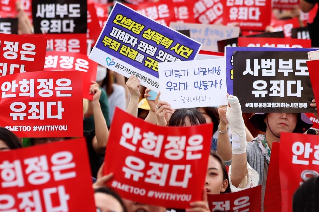 Women prosters hold a sign that says "An Hee-jung is Guilty" at a mass rally held in central Seoul on Saturday. (Yonhap)