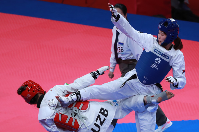 South Korea's Kim Jan-di lands a kick on opponent Nigora Tursunkulova of Uzbekistan in the semi-final round on Monday. Yonhap